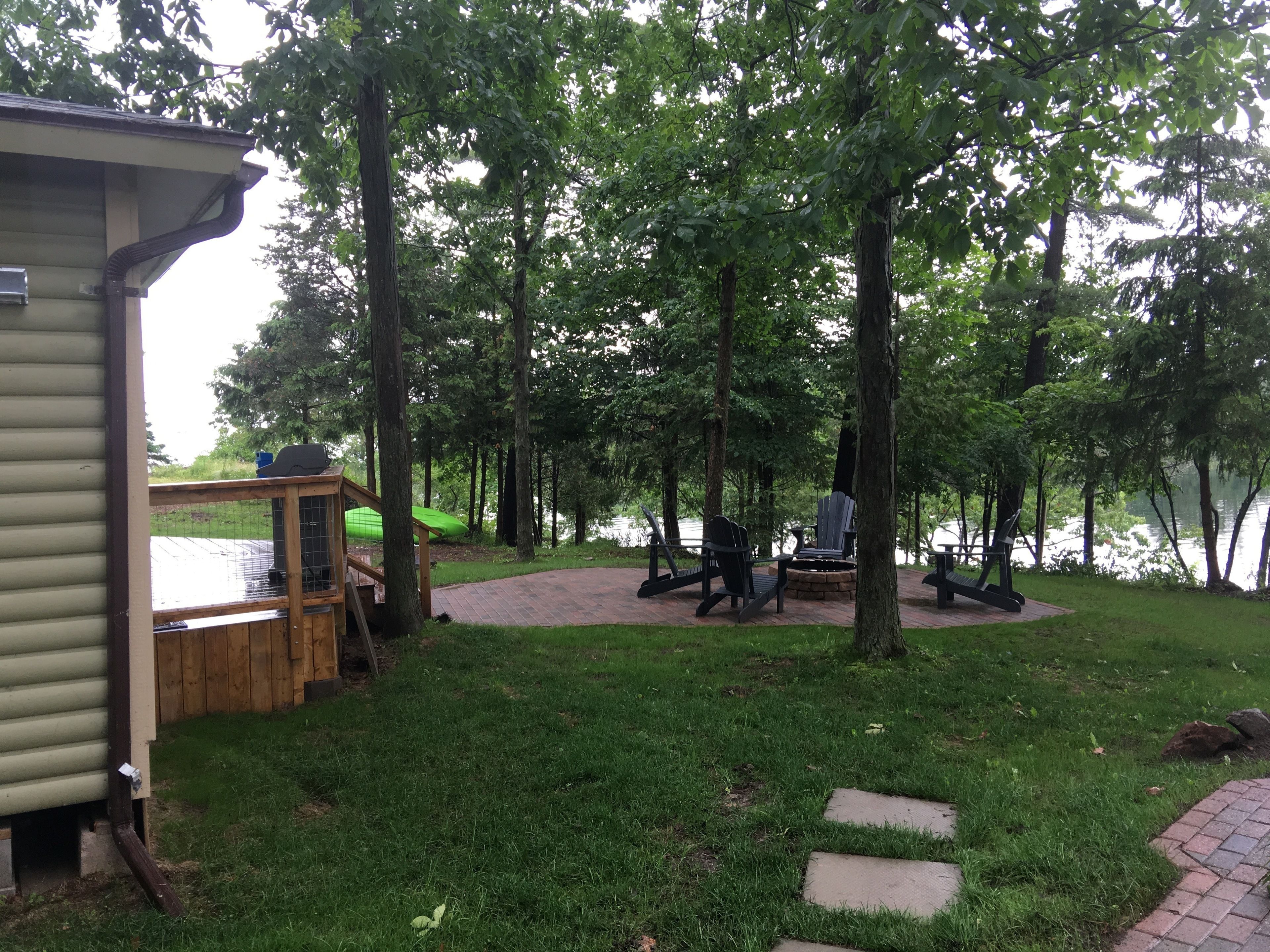 Une terrasse au bord du lac, dotée de meubles d’extérieur et d’une plateforme en bois.