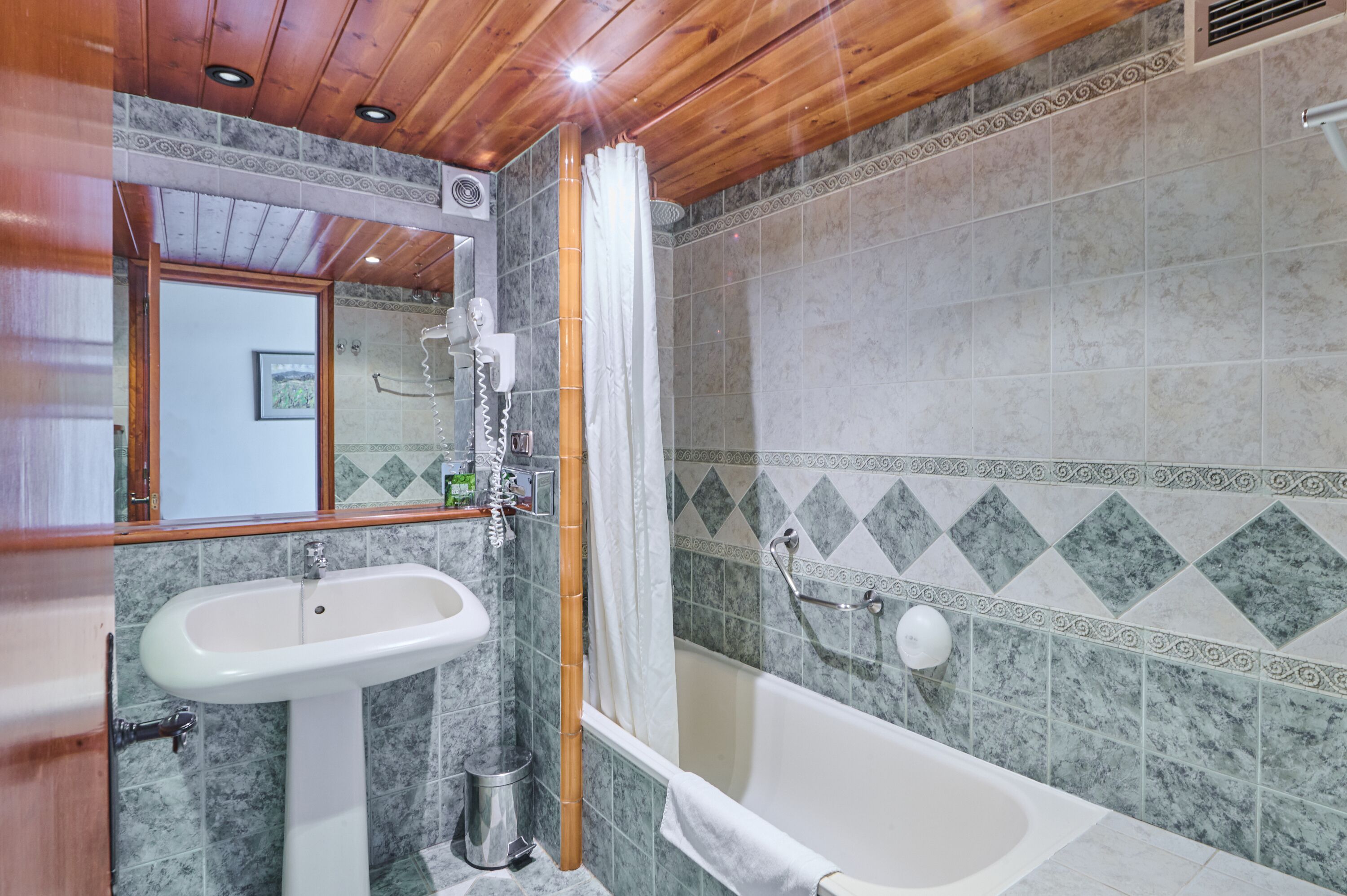 Un baño con lavabo, espejo, ducha y bañera.