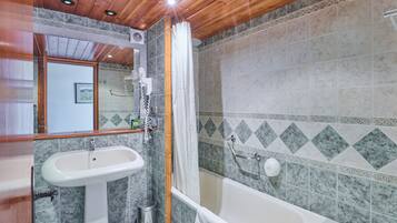 A bathroom with a sink, mirror, shower, and bathtub.