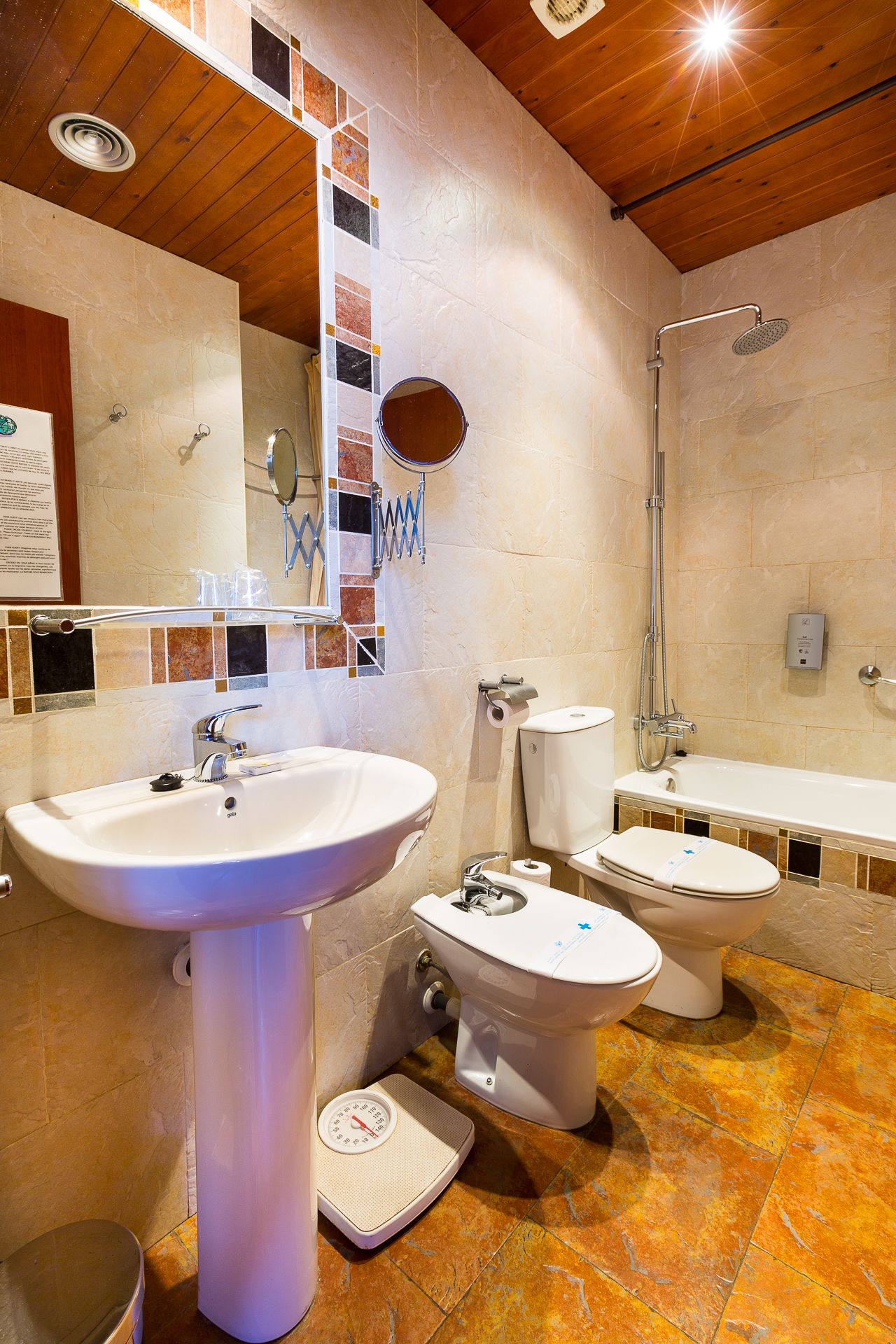 Un bagno con un lavandino spazioso, due servizi igienici, una doccia e uno specchio.