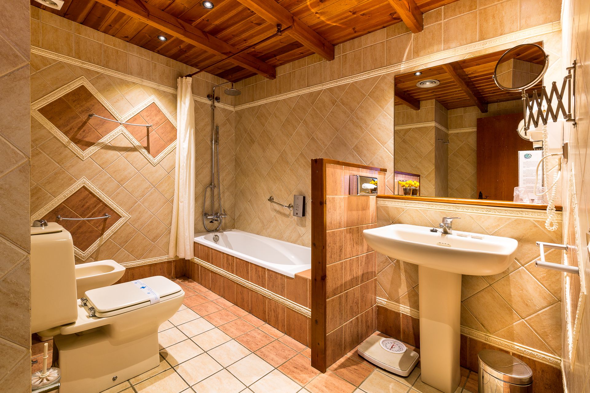 Un baño con bañera, inodoro, lavamanos y ducha.