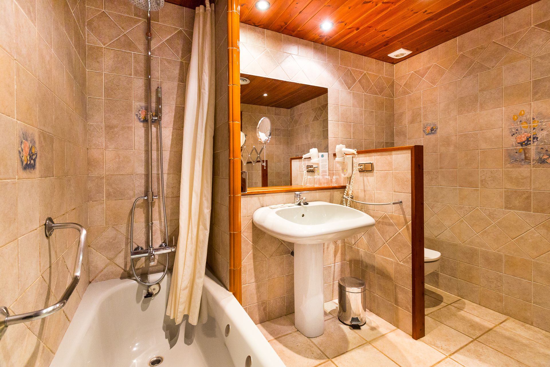 Une salle de bain équipée d’une baignoire, d’un lavabo, de toilettes et d’une douche avec un rideau.