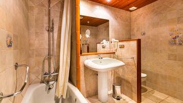 Une salle de bain équipée d’une baignoire, d’un lavabo, de toilettes et d’une douche avec un rideau.