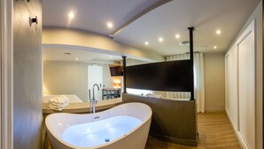 Un baño moderno con una bañera independiente, un tocador con espejo y una zona de ducha.