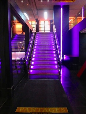 Staircase leading up to a glass door, flanked by walls and a sign reading 'PANTAGES'.