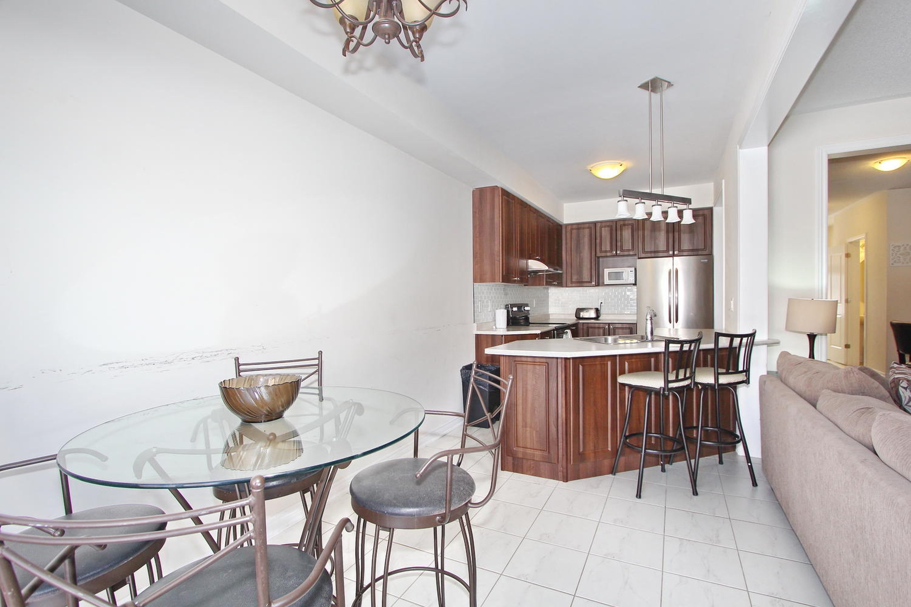 A modern kitchen with a central island, wooden cabinets, and stainless steel appliances.