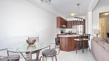Una cocina moderna con una isla central, armarios de madera y electrodomésticos de acero inoxidable.