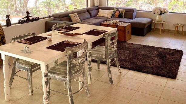 A spacious living area with a high thatched ceiling, a dining table with chairs, and a sofa set. - Maya Eco Village (Akumal)