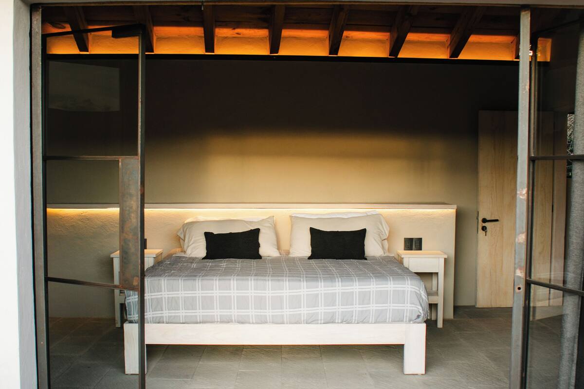 A bedroom with a bed, bedside tables, and a wardrobe.