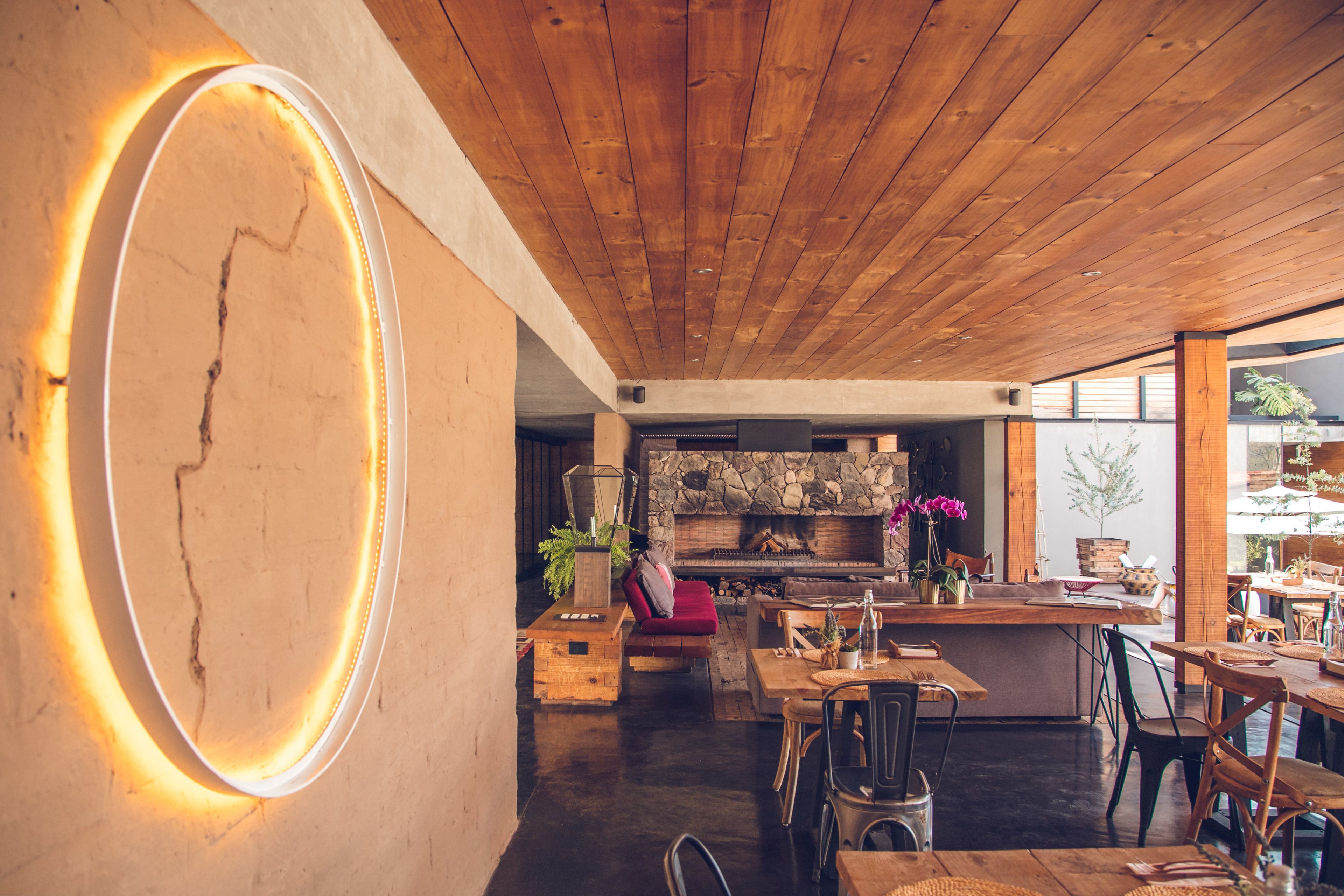 Een gezellig interieur met een houten plafond, een stenen openhaard en een barhoek.