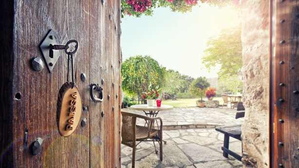 A rustic wooden door with a keyhole and a metal plate with the name "PANSSA". - Can Guillo (Pollenca)