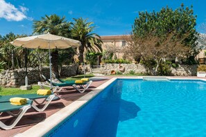 Una piscina al aire libre, tumbonas