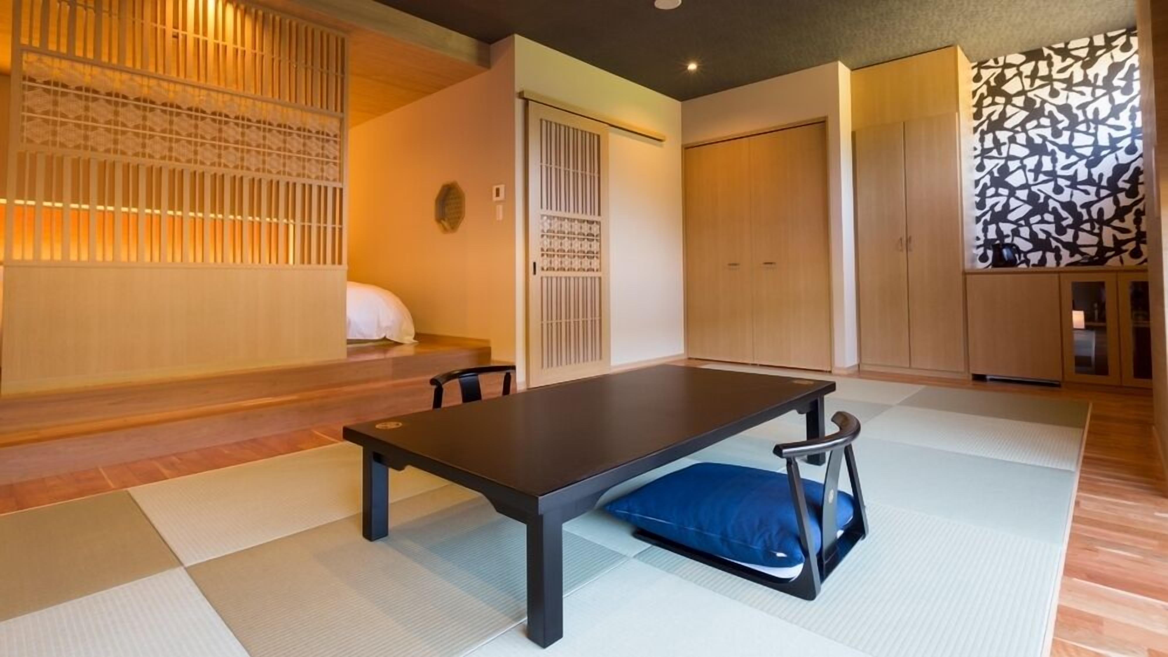 Una habitación japonesa tradicional con suelo de tatami, una mesa baja y puertas correderas.