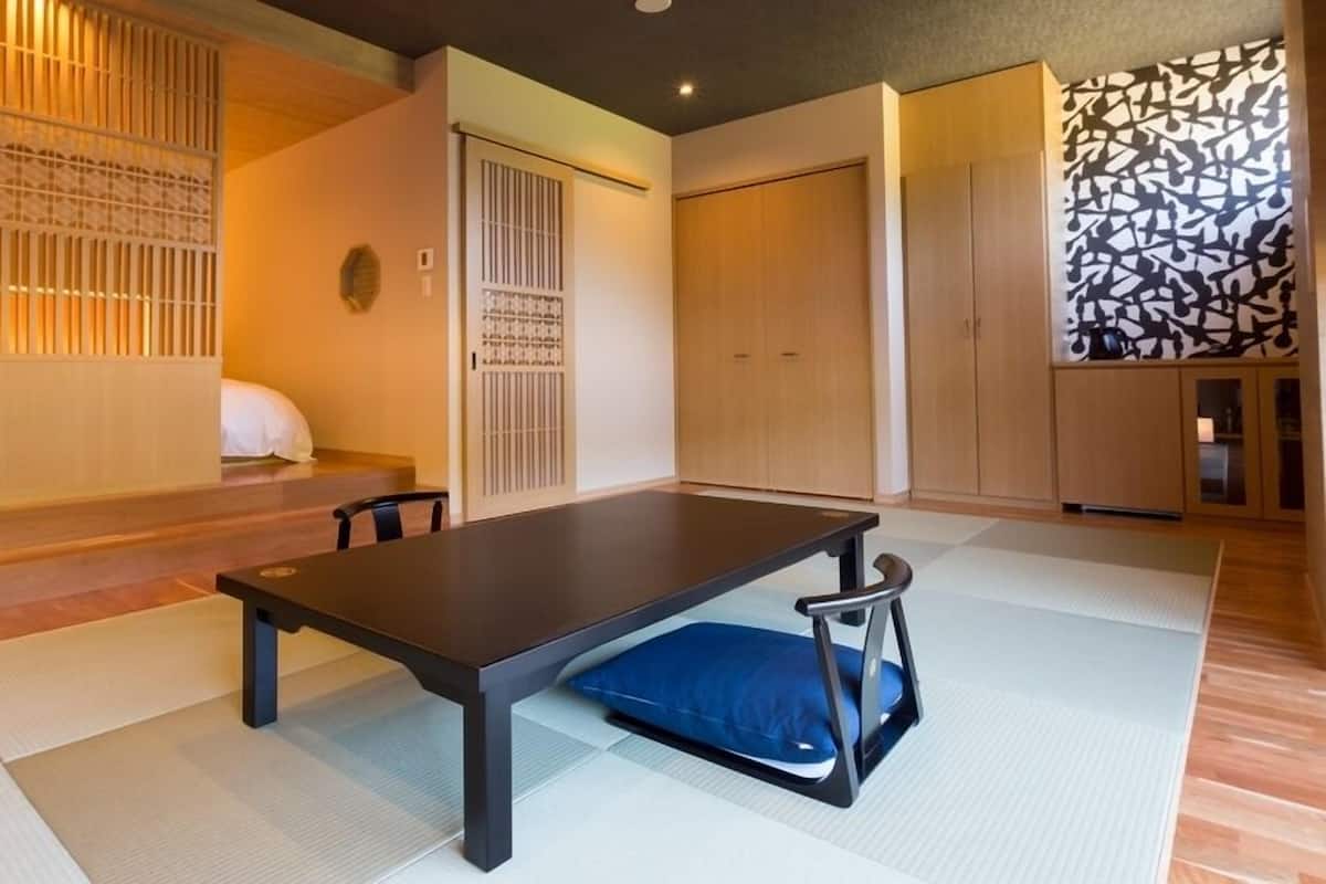 A traditional Japanese room with tatami flooring, a low table, and sliding doors.