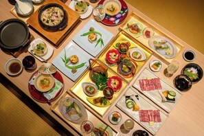 Diversos platos y bebidas dispuestas sobre una mesa de madera, probablemente para una comida o degustación.