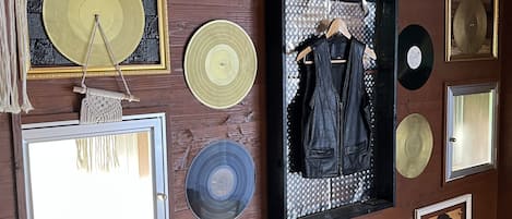 Una pared decorada con varios objetos enmarcados, entre ellos discos y una fotografía.