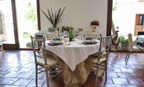 A dining area with a round table set for four, surrounded by four chairs.