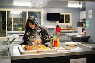 Una persona cocina en un bufé con varios condimentos y platos en la barra.