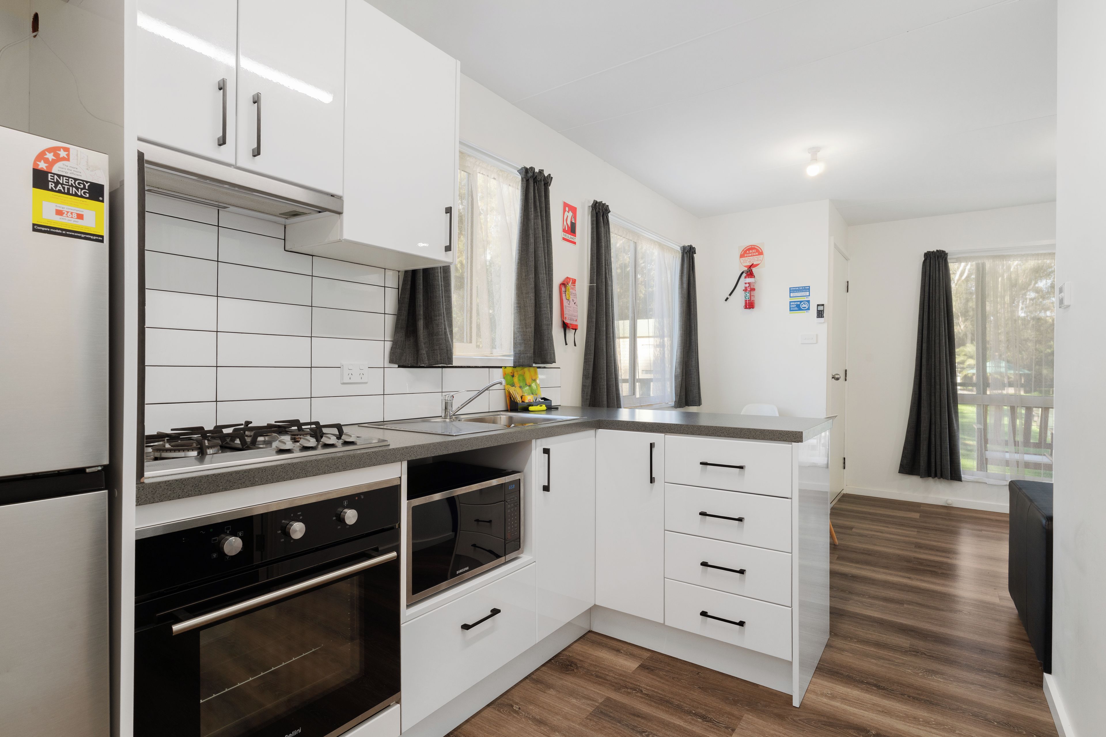 Une cuisine moderne avec des armoires blanches, une cuisinière en acier inoxydable et un four à micro-ondes.
