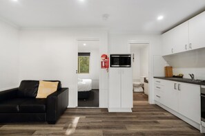 Une cuisine moderne avec des meubles blancs, un four à micro-ondes et un évier.