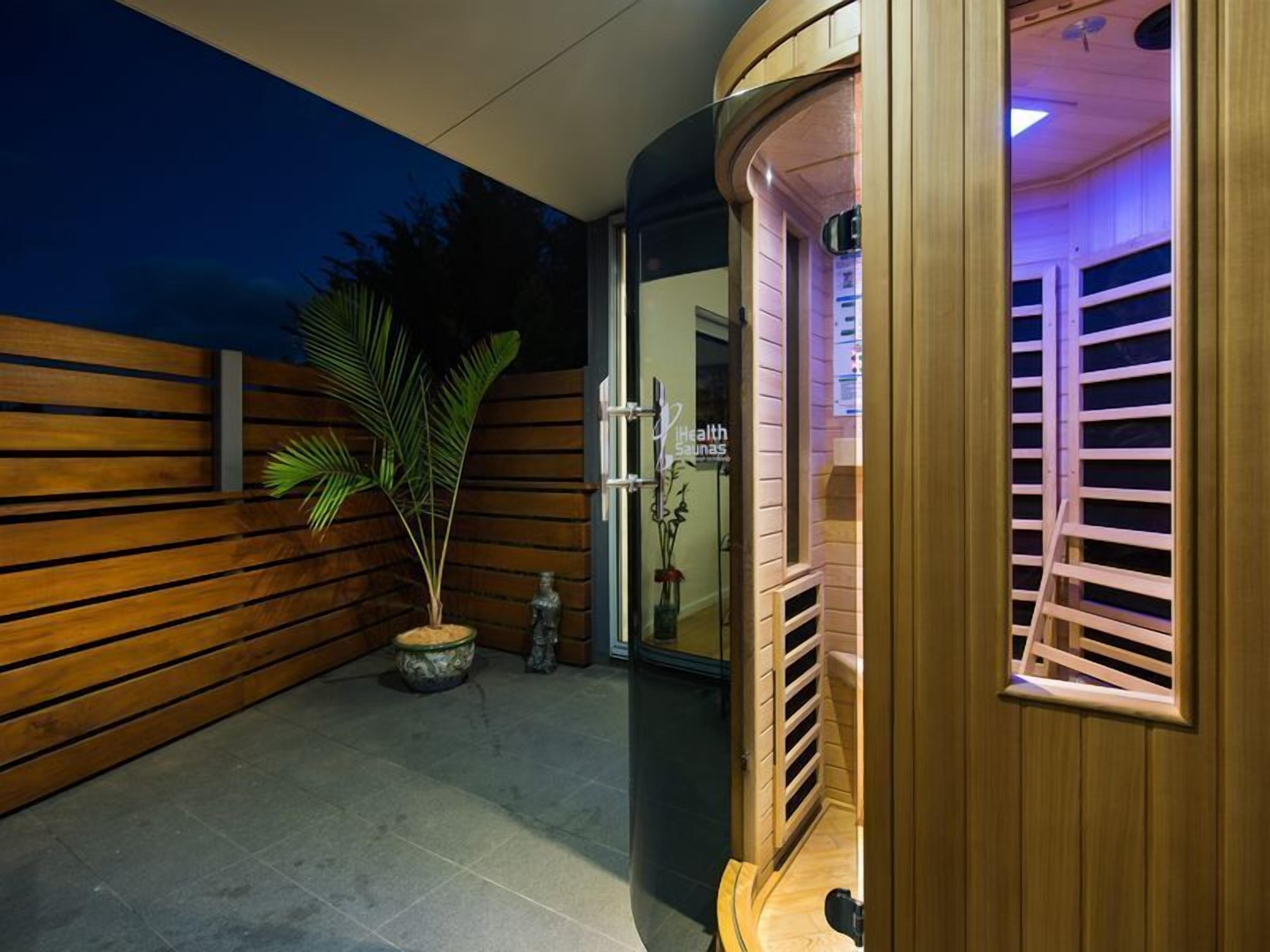 Un cuarto de spa con paredes de madera, una planta en maceta y una camilla de masaje.