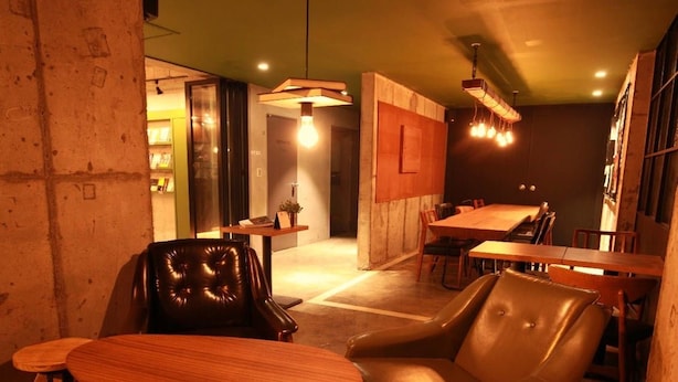 A cozy restaurant with leather chairs, wooden tables, and pendant lighting. - Hwon Guest House (Seoul)