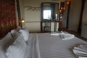 A hotel room with a large bed, a desk, and a chair. - The Adventure Mountain Club (Takua Thung)