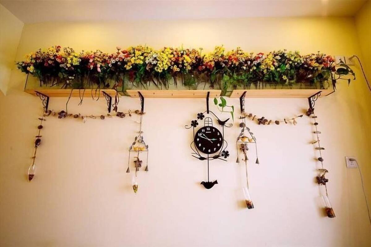 Una pared con un reloj y adornos colgantes.