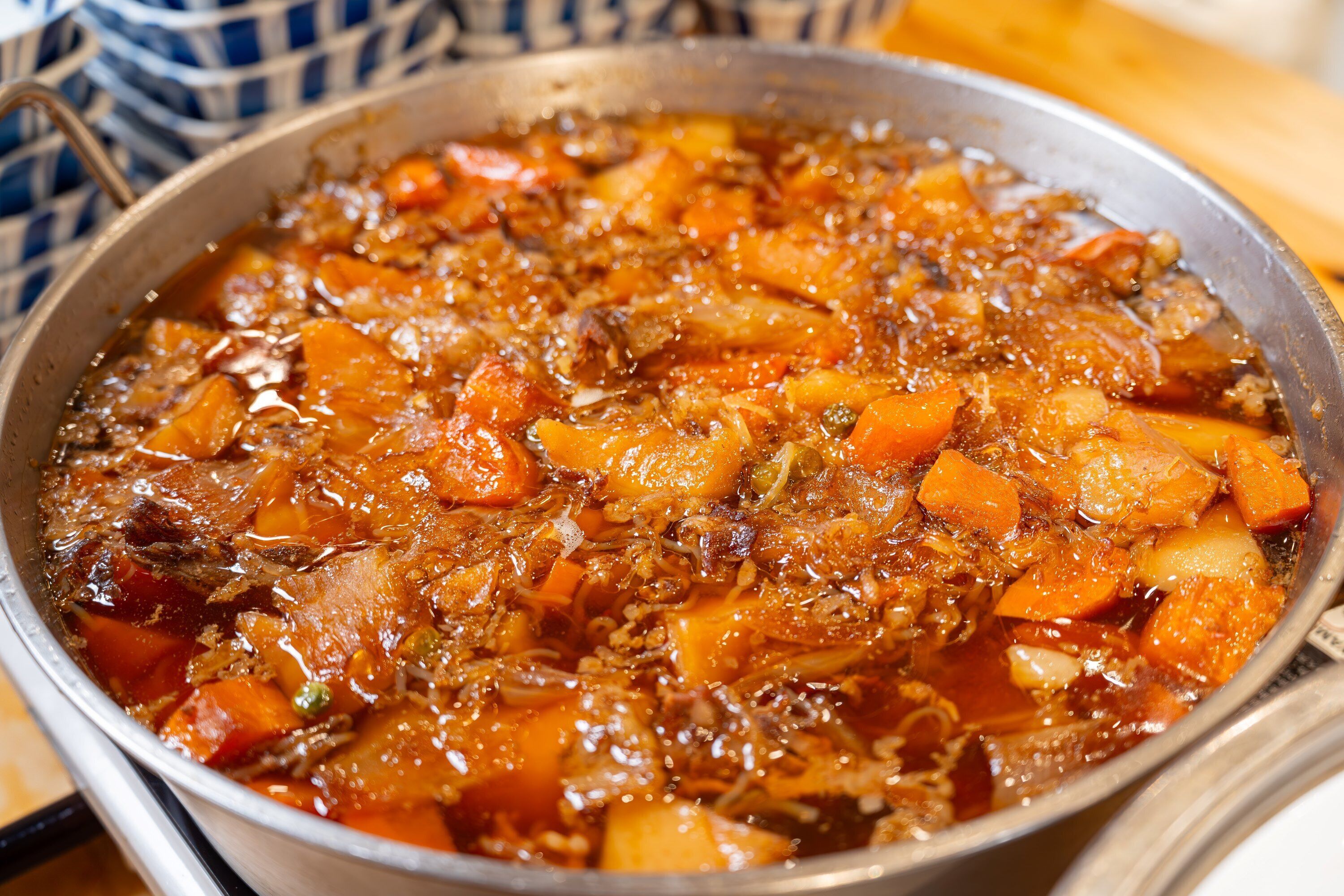 A close-up of a stew with chunks of meat and vegetables in a pan.