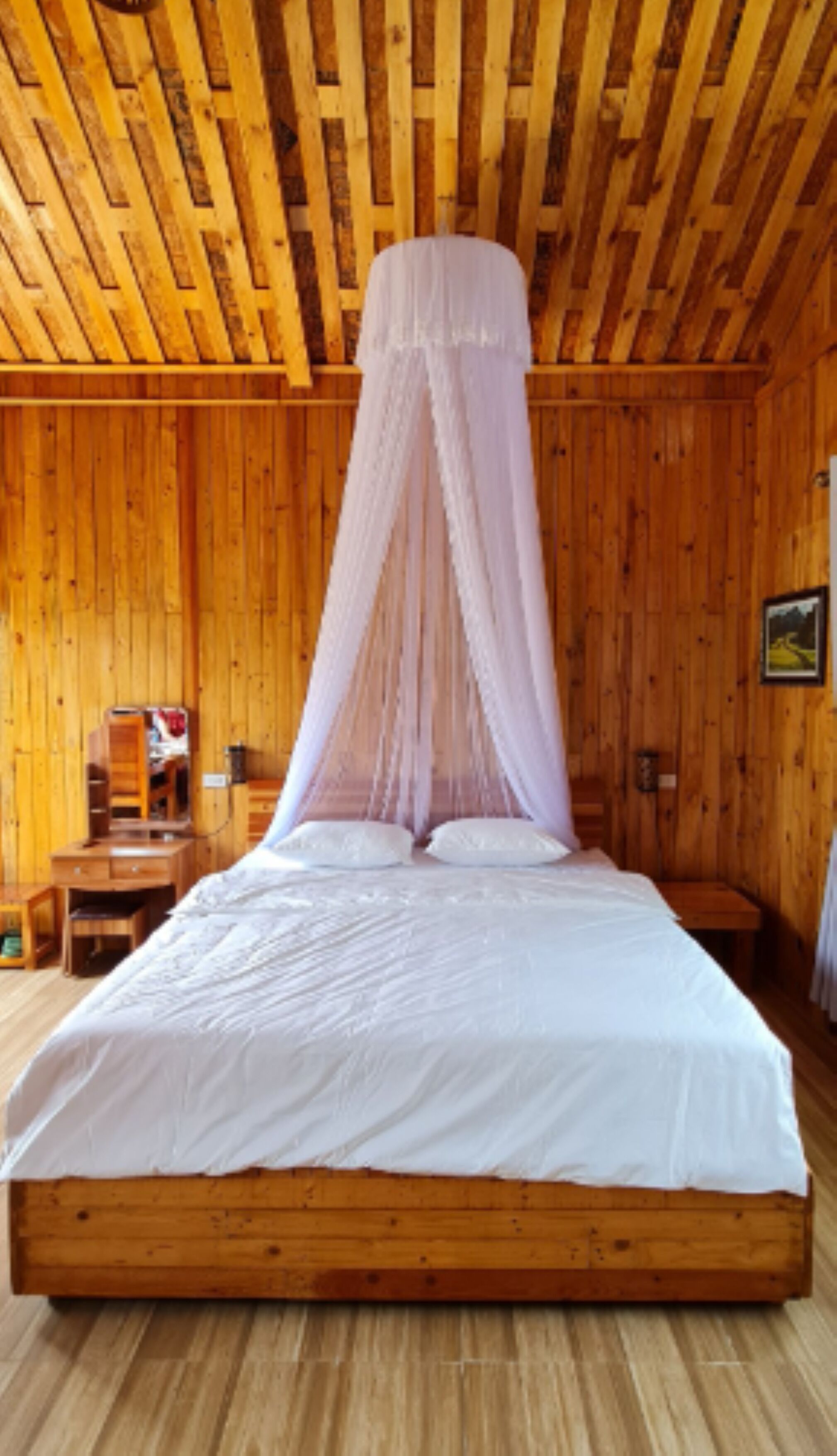 A wooden room with a bed under a canopy.