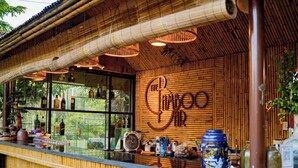A bamboo-themed bar with a large sign reading "The Bamboo Bar," a glass display case with bottles, and a counter with various items. - Ninh Binh Eco Garden (Tay Hoa Lu)