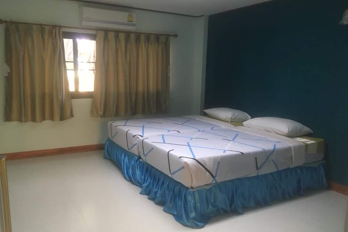 Een slaapkamer met een bed, gordijnen en een raam.