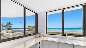 Una cocina moderna con amplios ventanales con vistas a la playa.