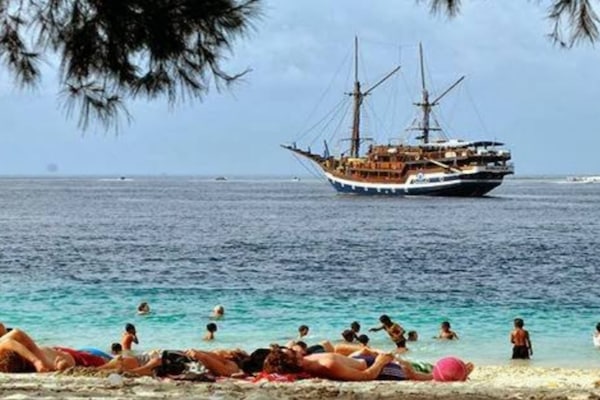 Playa en los alrededores, playa de arena blanca y bote de remos o canoa