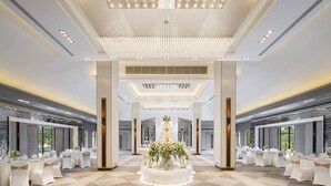 A spacious banquet hall with a central cake display, high ceilings, and a checkered floor. - Eastin Thana City Golf Resort Bangkok (Bang Phli)