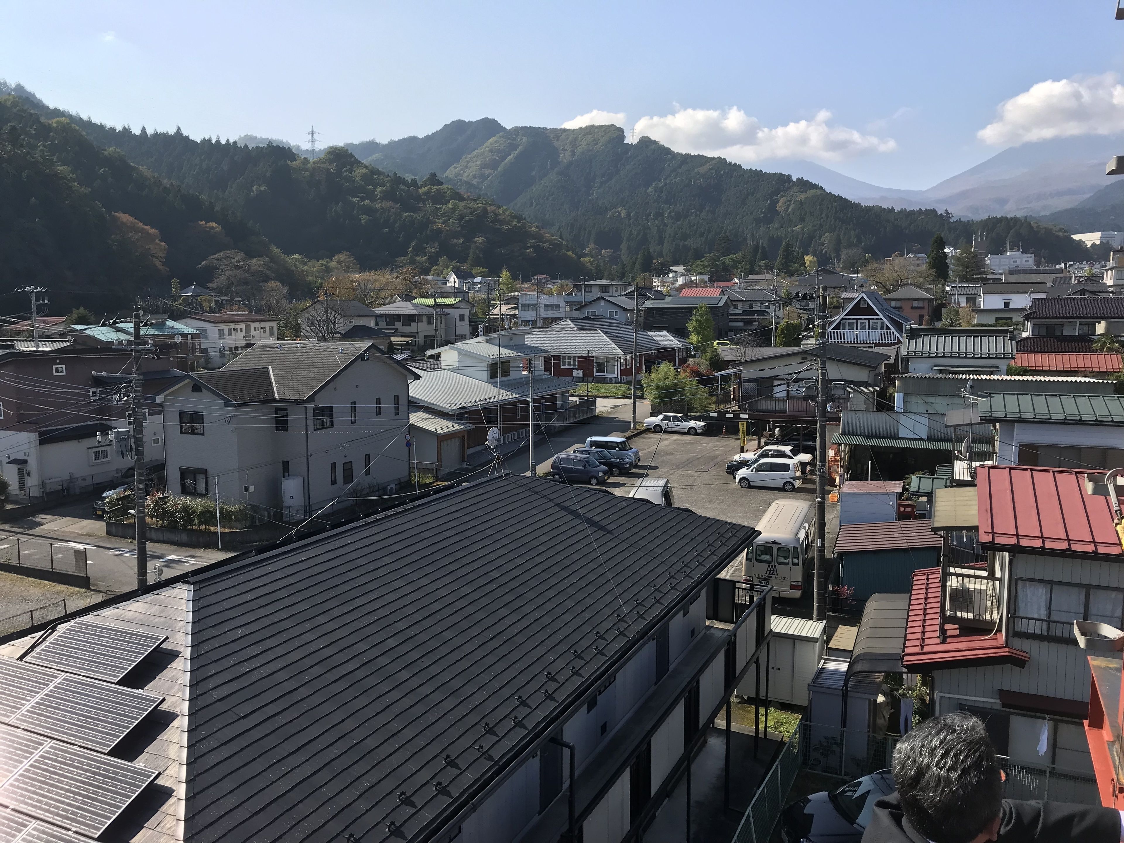 A residential area with houses, a parking lot, and a mountain backdrop.