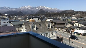 A town with buildings and a mountain range in the background. - Hotel Famitic Nikko (Nikko)