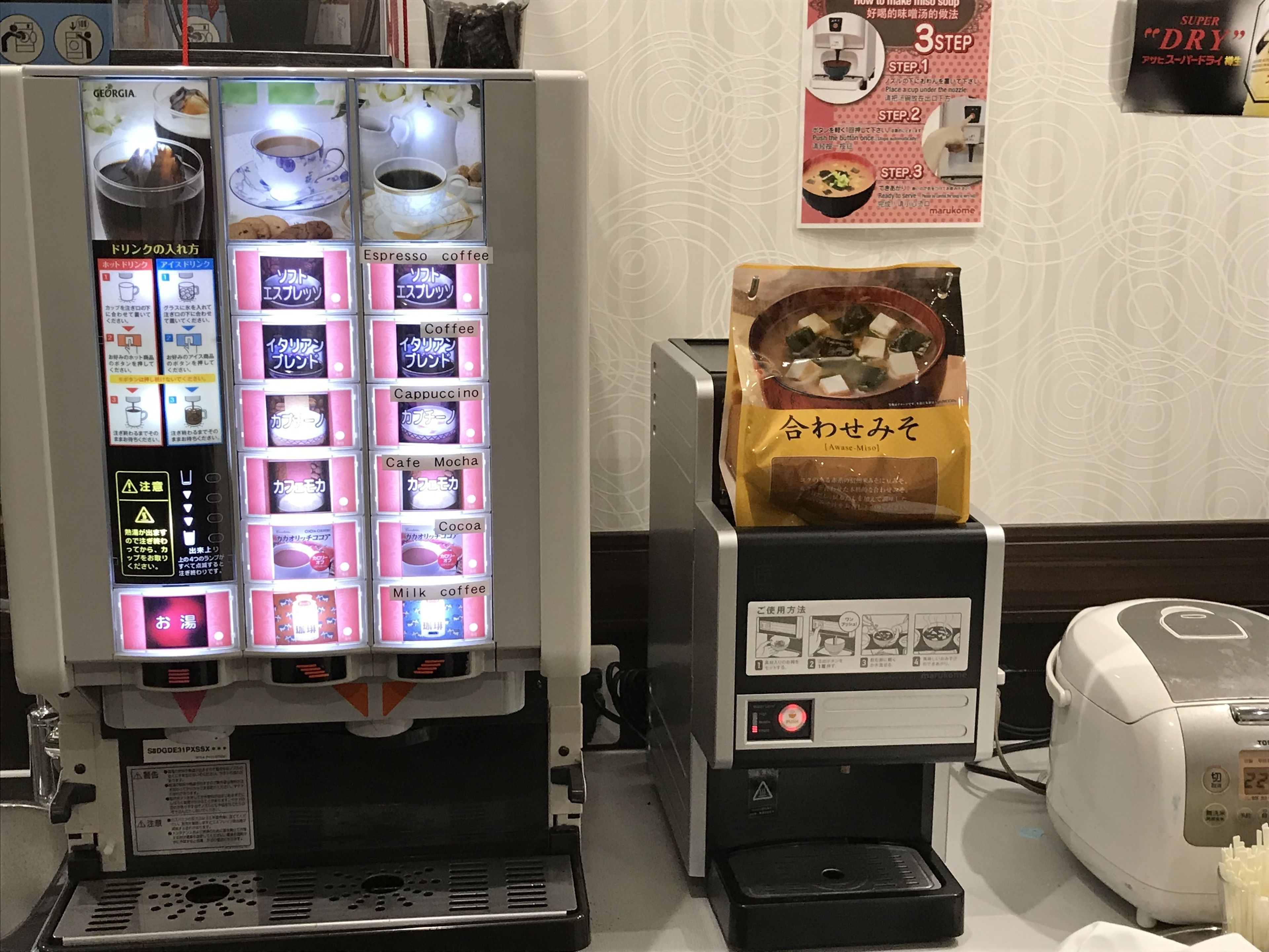 A coffee machine with multiple drink options and a bag of instant coffee on top.