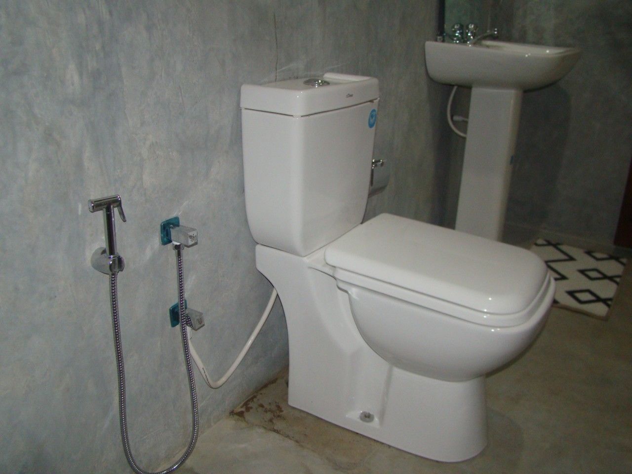 A bathroom with a toilet, a shower, and a sink.