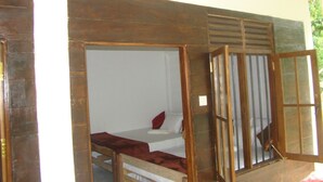 A room with a bed, a window with bars, and a wooden door. - Vini Villa (Deniyaya)