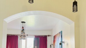 A kitchen with white cabinets, a marble countertop, and hanging pendant lights. - South Marina Fiorita house (Hurghada)