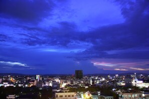 A cityscape at night with illuminated buildings and a prominent tower in the center.