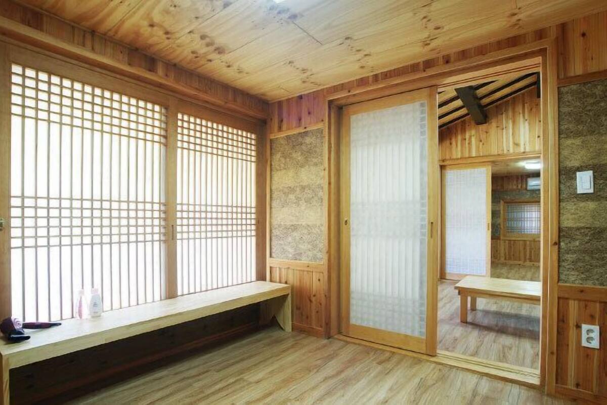 A traditional Japanese room with tatami flooring, sliding doors, and a wooden bench.
