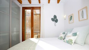 A bedroom with a bed, a sliding glass door leading to a balcony, and wall-mounted artwork. - Bright Studio in the heart of Palma with Balcony, Wifi, AC, Great for Couples (Palma)