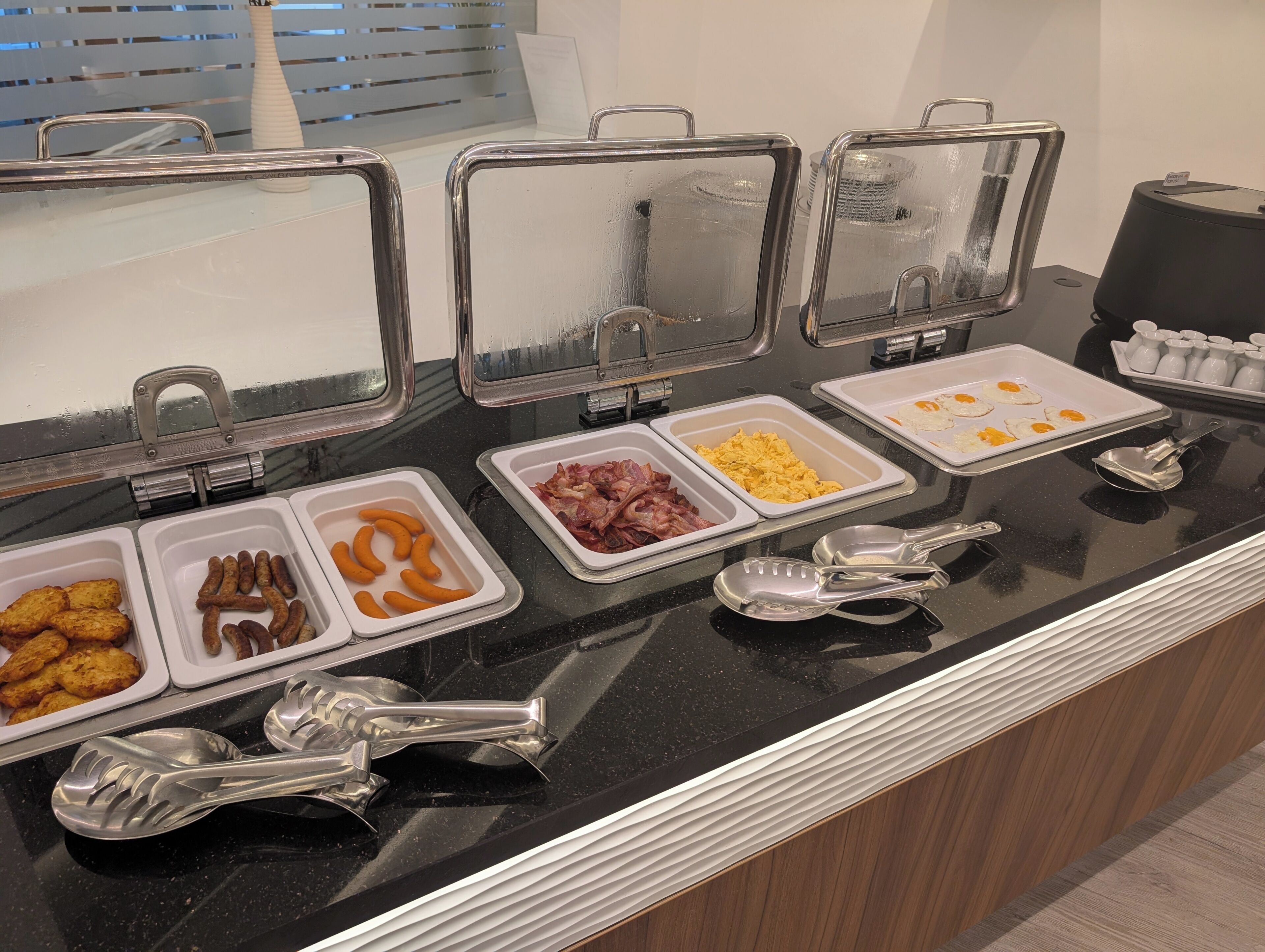 Balcão de buffet com diversos alimentos e utensílios.