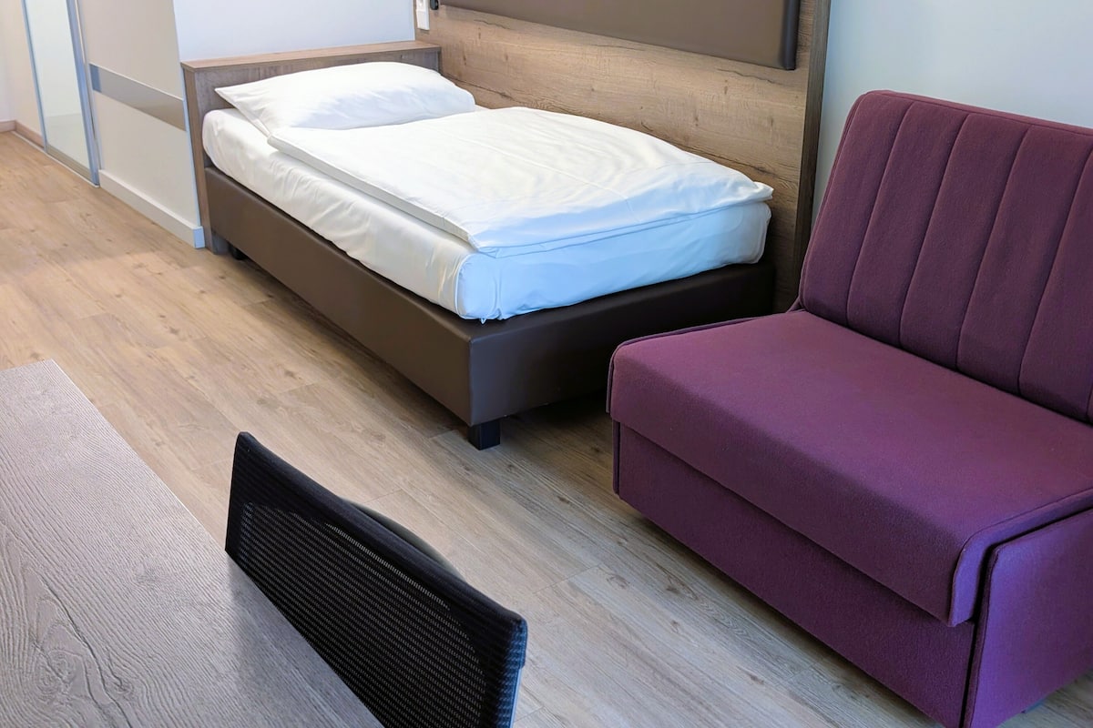 أغطية فراش متميزة وخزنة داخل الغرفة ومكتب وتجهيزات عازلة للصوت