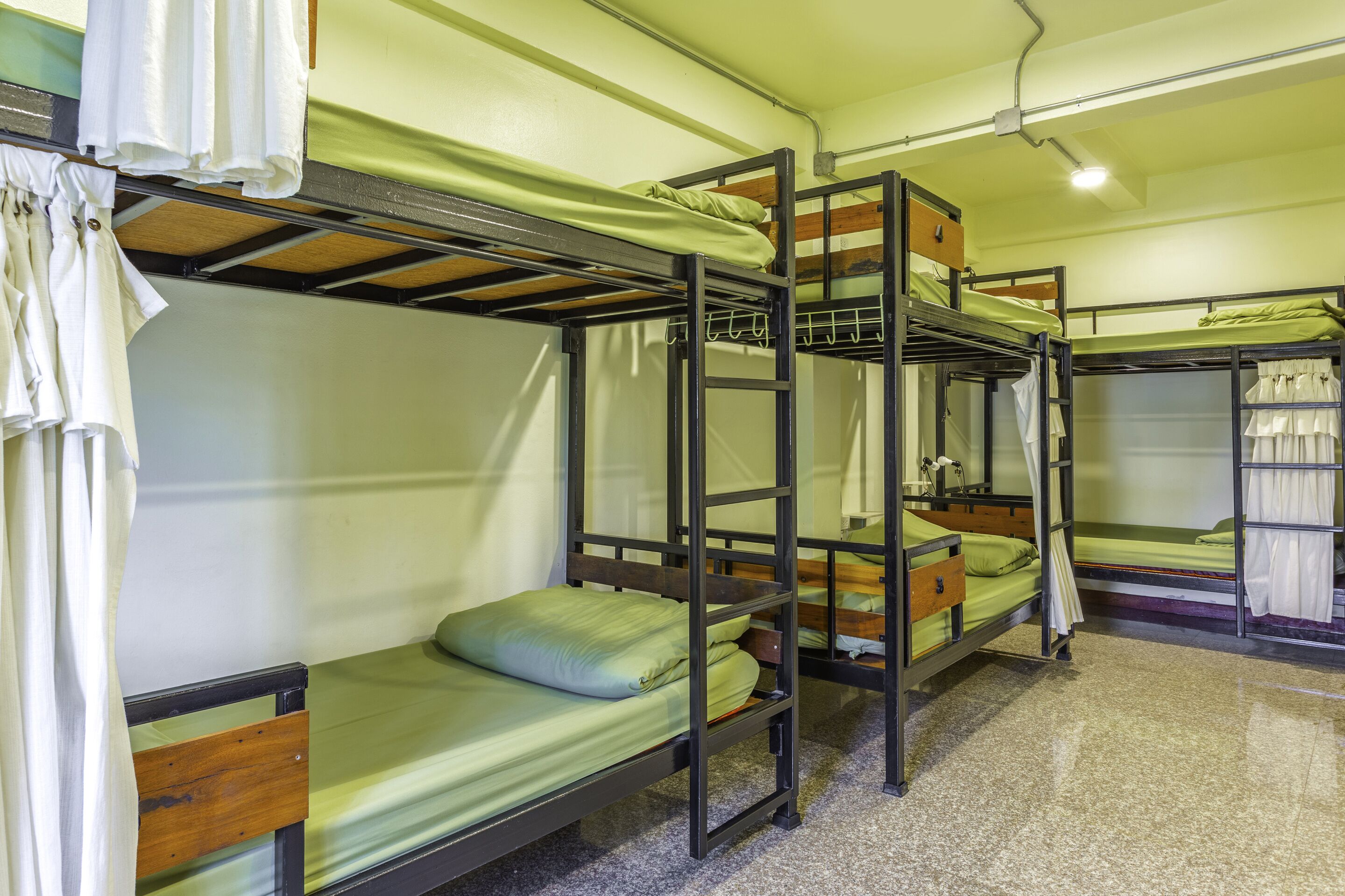 Un dormitorio con literas, una escalera y una pequeña mesa con una lámpara.