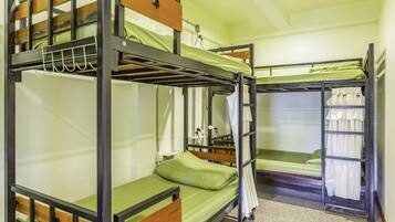 A bunk bed room with a wooden ladder, a desk, and a chair.