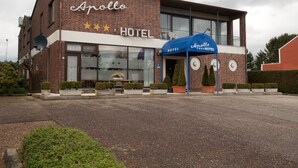 A two-story brick building with a sign reading "Apollo Hotel" and a blue awning. - Hotel Apollo (Zutendaal)