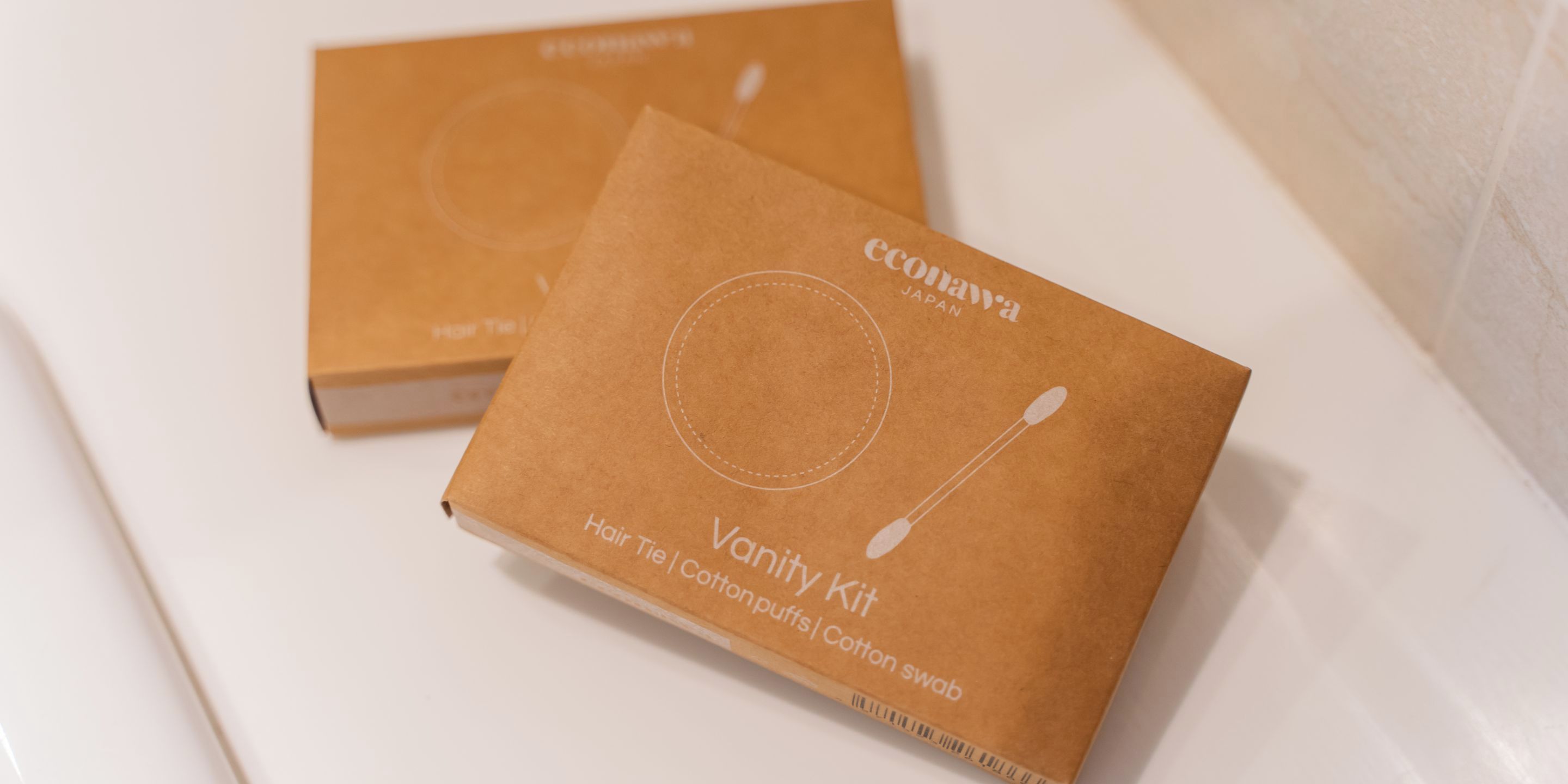 Two brown boxes labeled 'Vanity Kit' with items like hair ties and cotton swabs.
